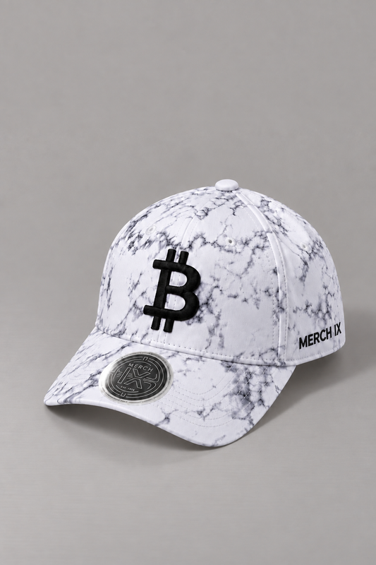 Angled view of MERCH IX white marble Bitcoin baseball cap featuring gray marble detailing, raised black Bitcoin embroidery, black MERCH IX side branding, and a metallic silver visor sticker.