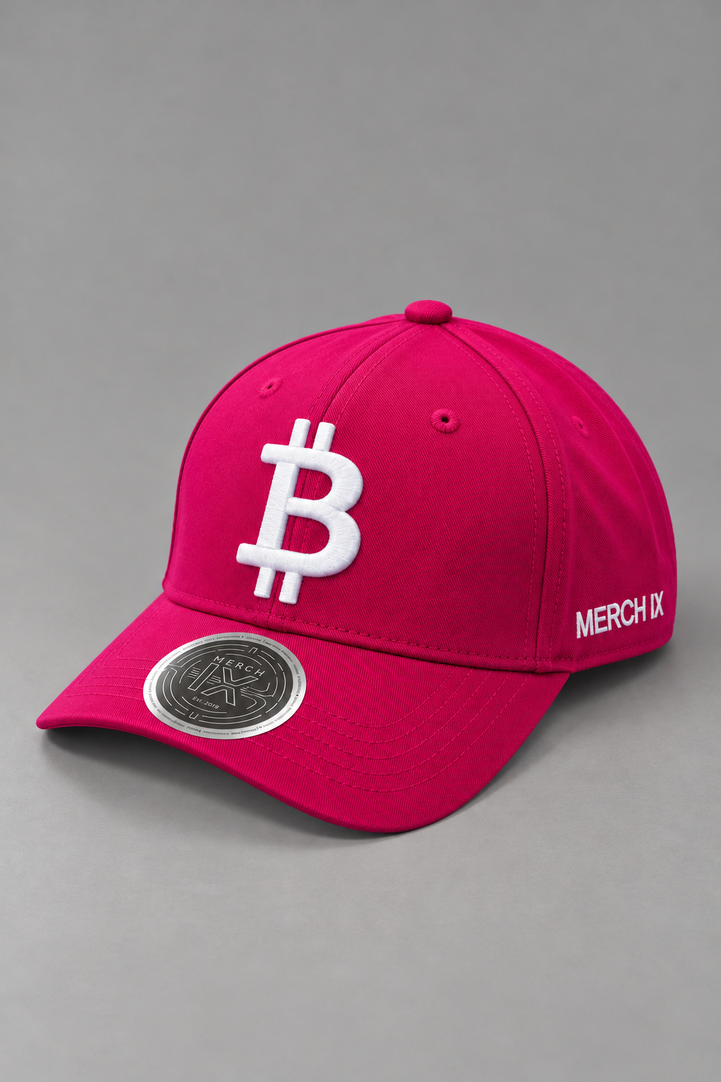 Hot pink Bitcoin baseball cap with raised white Bitcoin embroidery, white MERCH IX side branding, and metallic visor sticker.
